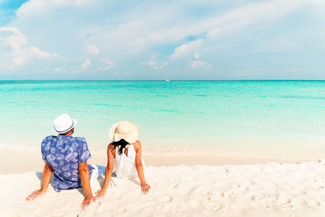 Traveller couple relaxing on a beach in the Maldives