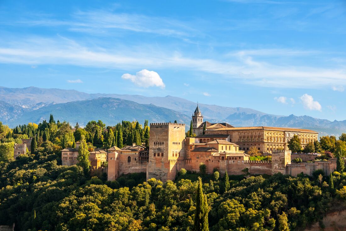 The epic exterior of the Alhambra Palace in the green hills of Granada, Spain 