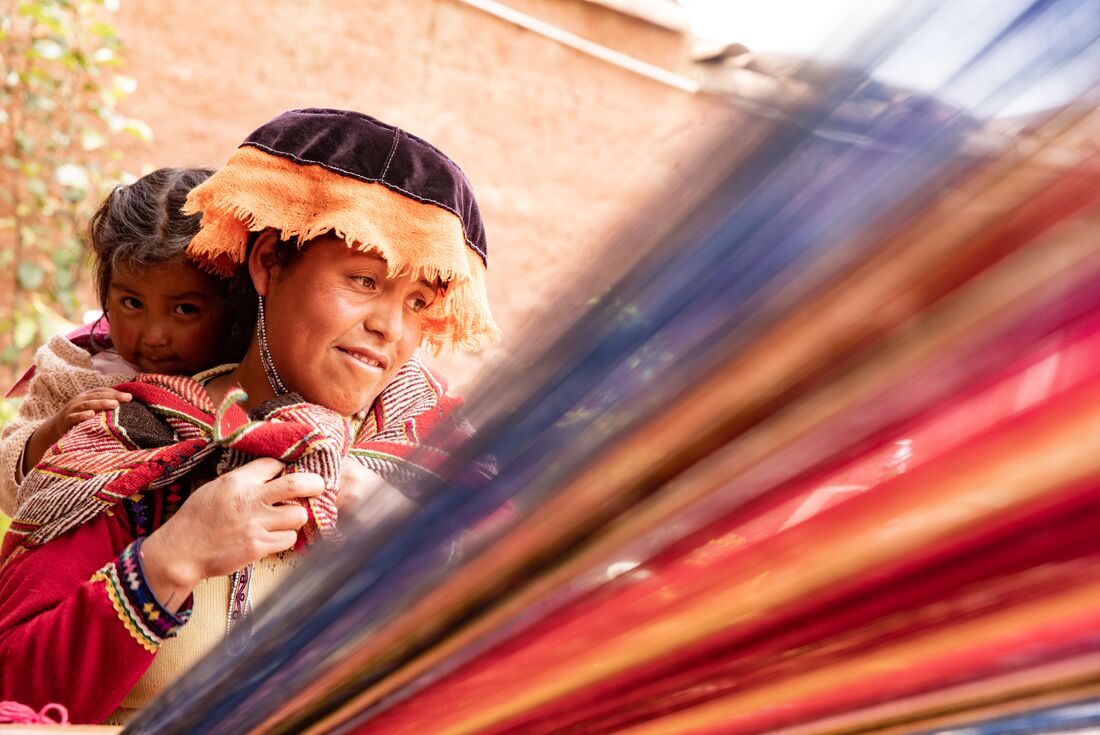 Local mother and child during weaving demonstration in Sacred Valley Ollantaytambo Peru