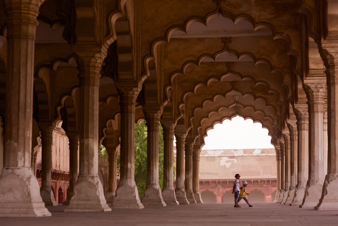 Children play among the intricate pillars of Agra's Red Fort in India's Golden Triangle