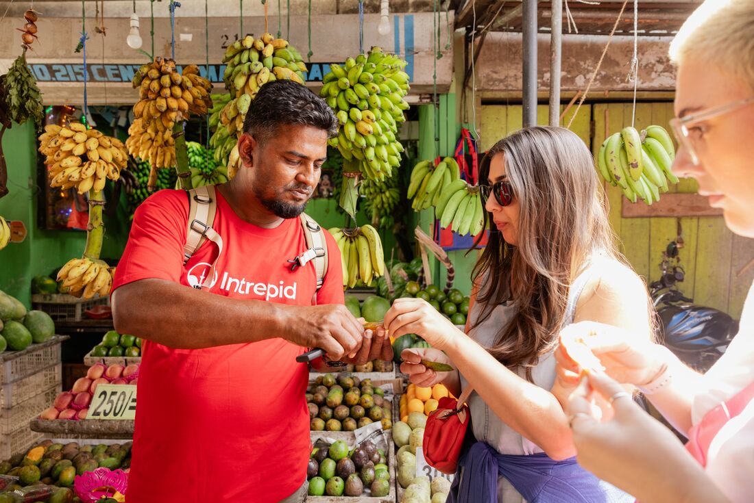 Leader with travellers having market tastings in Kandy, Sri Lanka