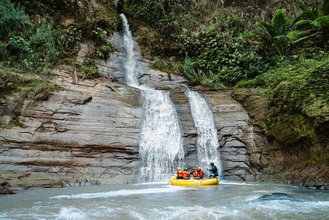 Travellers on raft in front of a waterfall in Navua River, Fiji