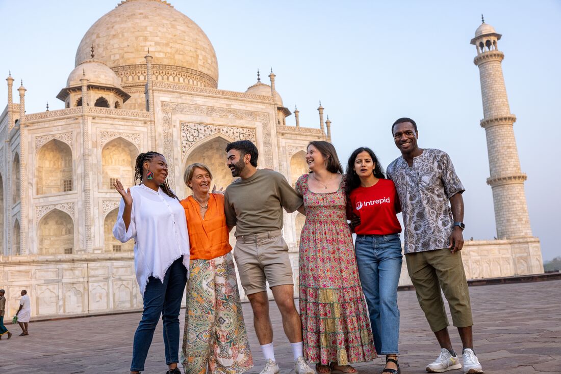 Travellers laugh together in a group photo at the Taj Mahal near Agra in Rajasthan India