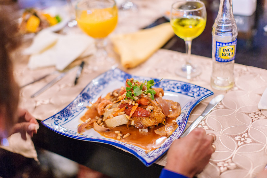Traveller looks at a beautifully presented meal on an undulating plate with Peruvian cola at the end of the Inca Trail
