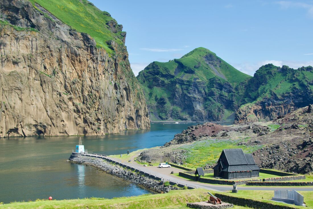  Wide view of Westman Island in Iceland, surrounded by water and green rock side