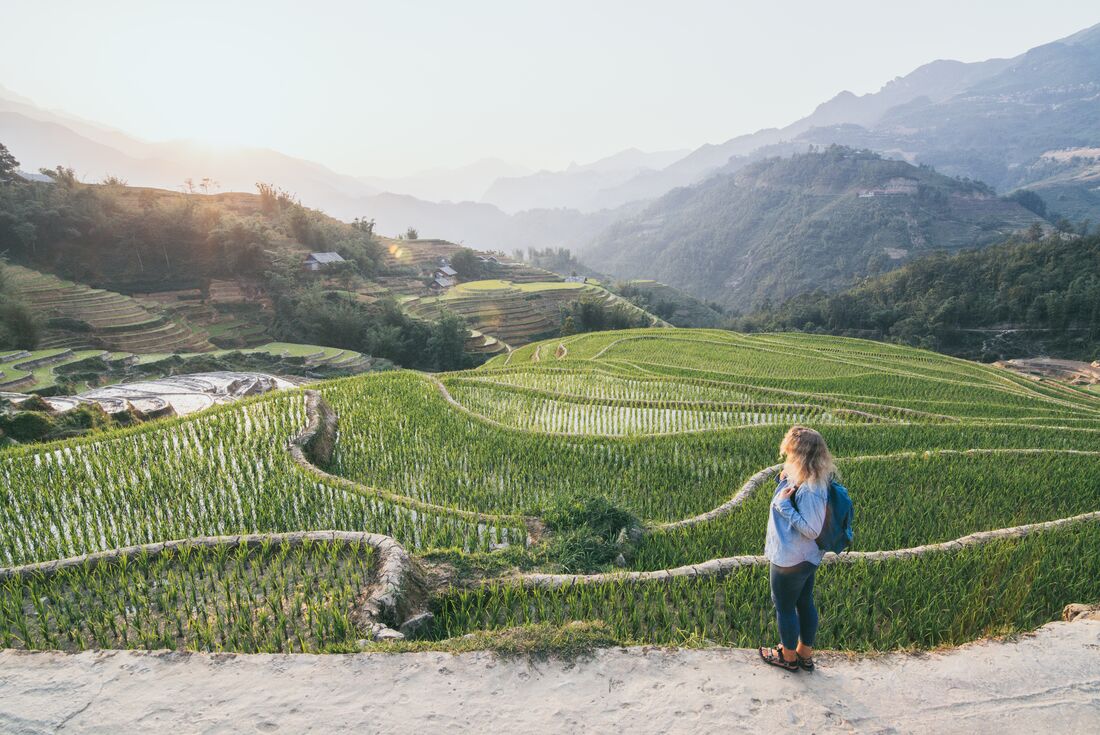 Intrepid traveller on a path taking in the carved hills of Sapa's rice terraces in north Vietnam