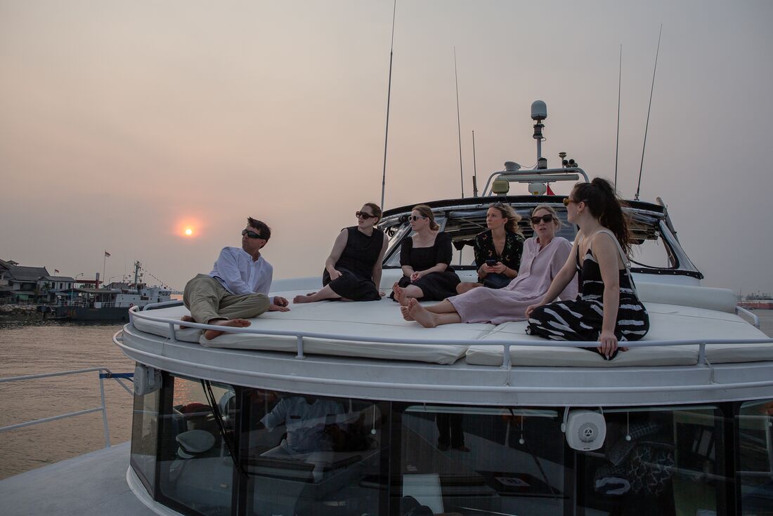Travellers relaxing on the deck of a sunset cruise in Sanur, Bali