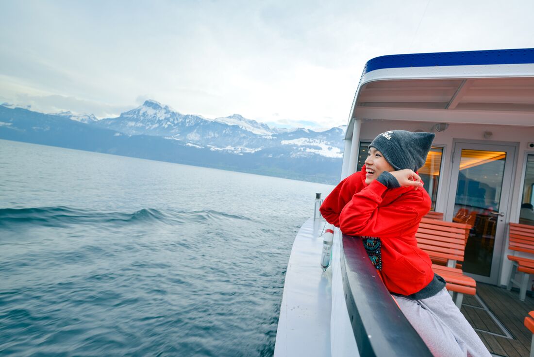 Intrepid traveller looks out from boat ride across Lake Lucerne in autumn