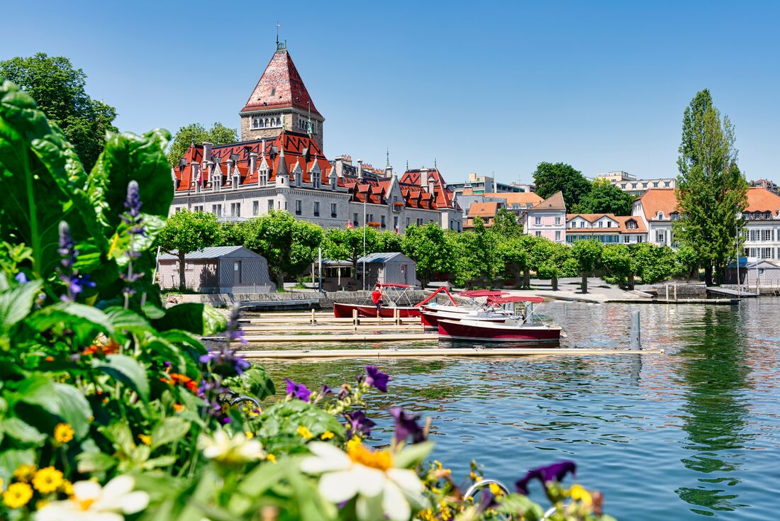 Brightly coloured Chateaux D'ouchy with flowers and docks on Lake Leman in Lausanne, Switzerland