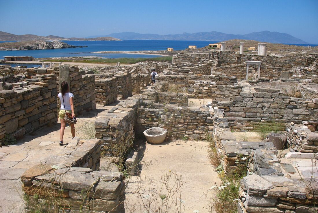 Walking throught the stone walled footprints of Greek ruins of Delos island in the Cyclades