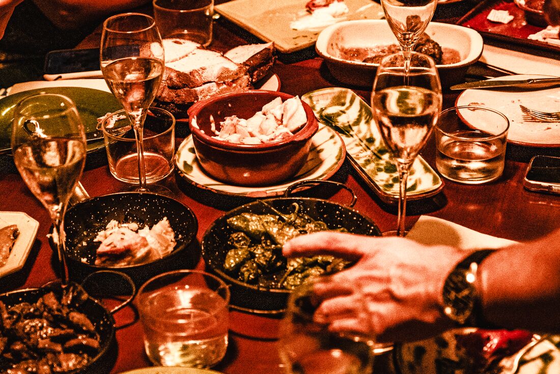A table in a restaurant at night with a spread of tapas and fresh wine