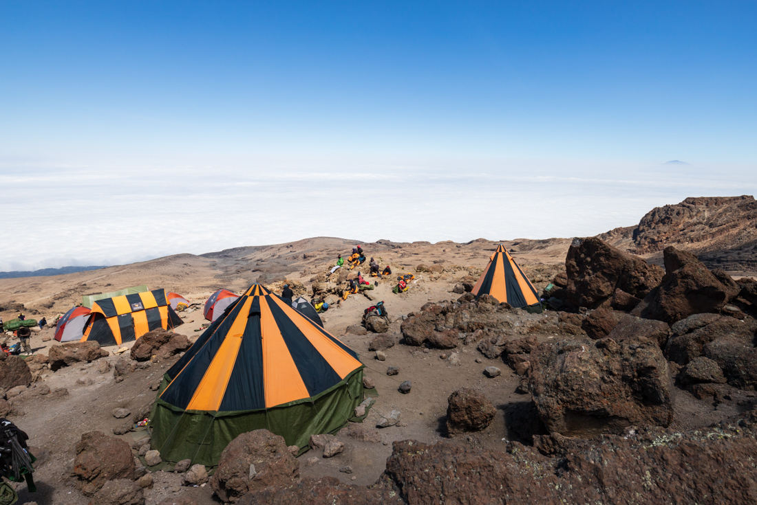 Orange striped conical tents at Barafu Camp on the side of Mount Kilimanjaro at 4703 meters