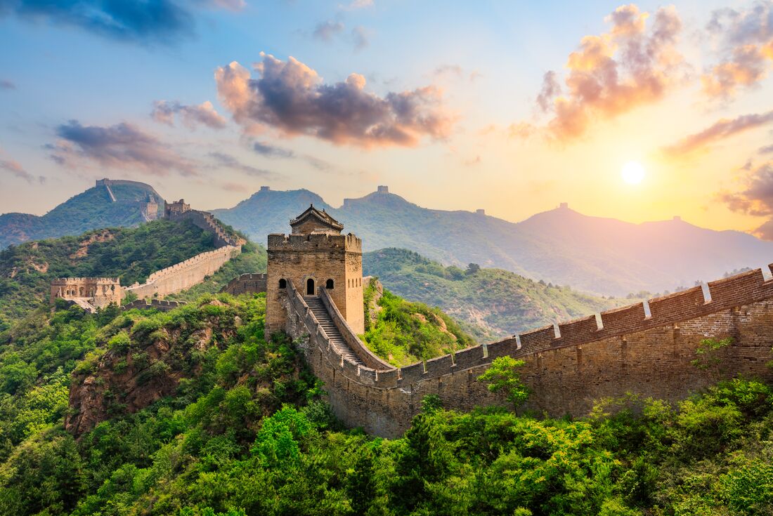 The Great Wall of China hit by the rising sun over the mountain peaks in northern China