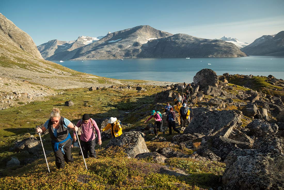 Travellers on hike near Fjord in Greenland