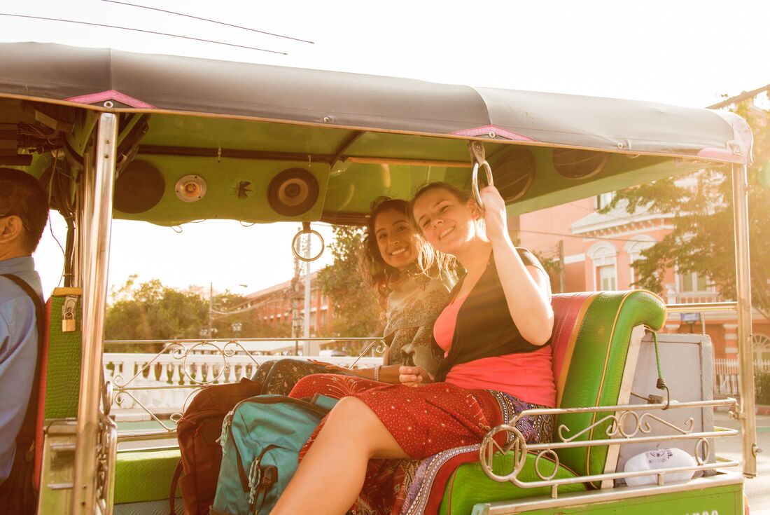Travellers enjoy a tuk-tuk ride in the afternoon in Bangkok
