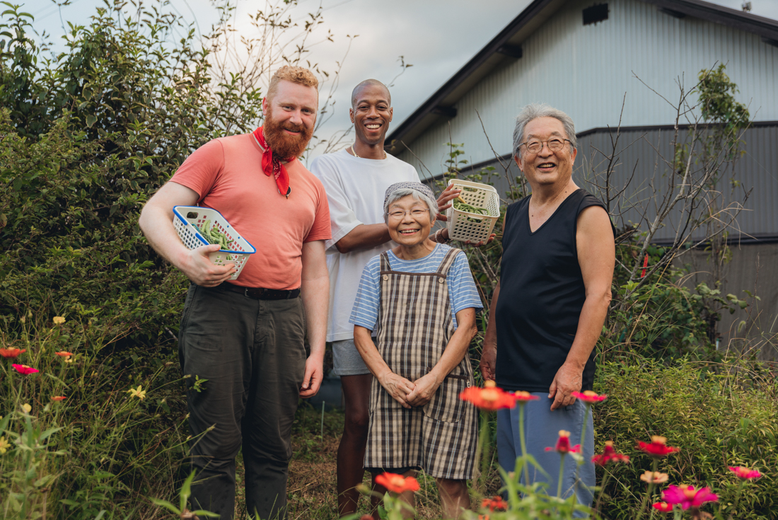 Intrepid travellers pose with the Hosts of the homestay Hananeko in Kawane, with baskets of fresh-picked vegetables