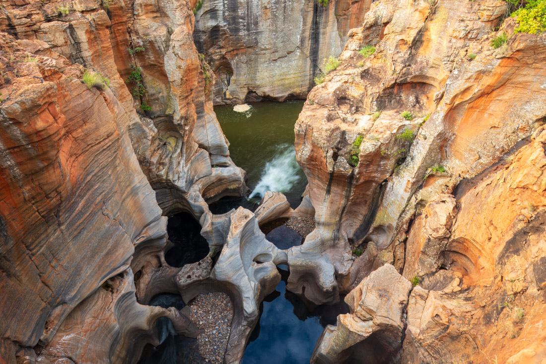 Deep round crevices formed in a river's path in a canyon are Bourke's Luck Potholes on the Panoramic route
