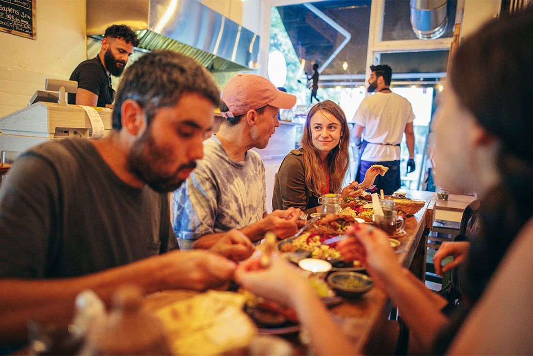 Group of travellers enjoying a meal together inside European restaurant