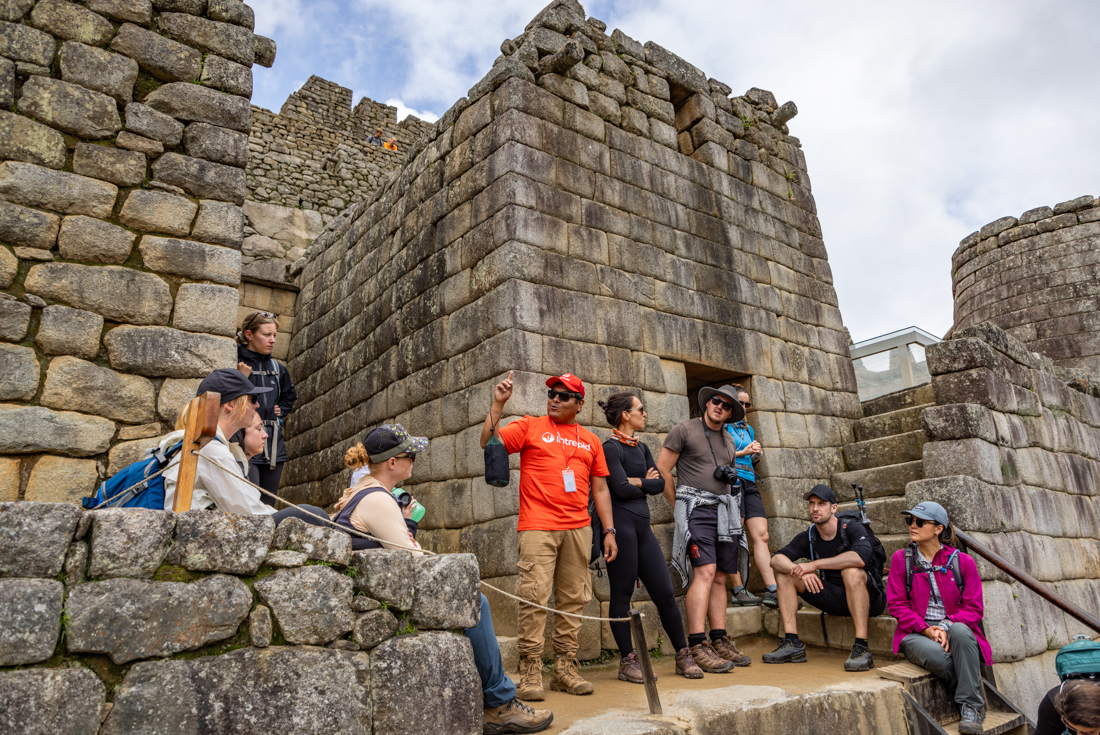 Surrounded by Machu Picchu stone walls Intrepid leader talks about the history of the place on the Inca Trail