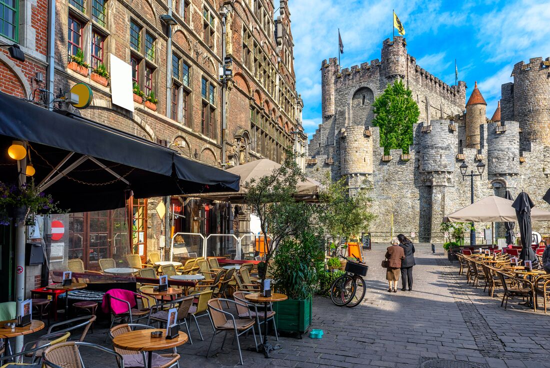 City streets lined with cafes and old castle in Ghent, Belgium