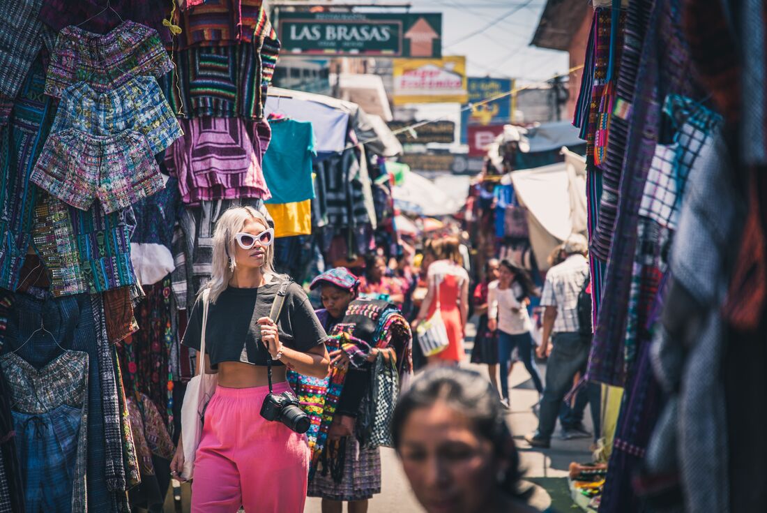 Traveller walking through colourful and populated Chichicastenango markets in Guatemala