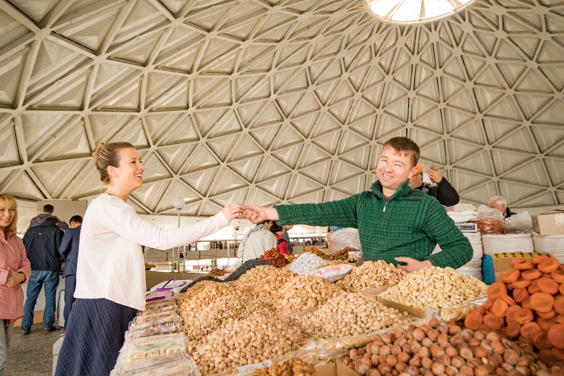 Traveller shares a happy moment with a Chorsu Bazaar vendor in Tashkent, Uzbekistan